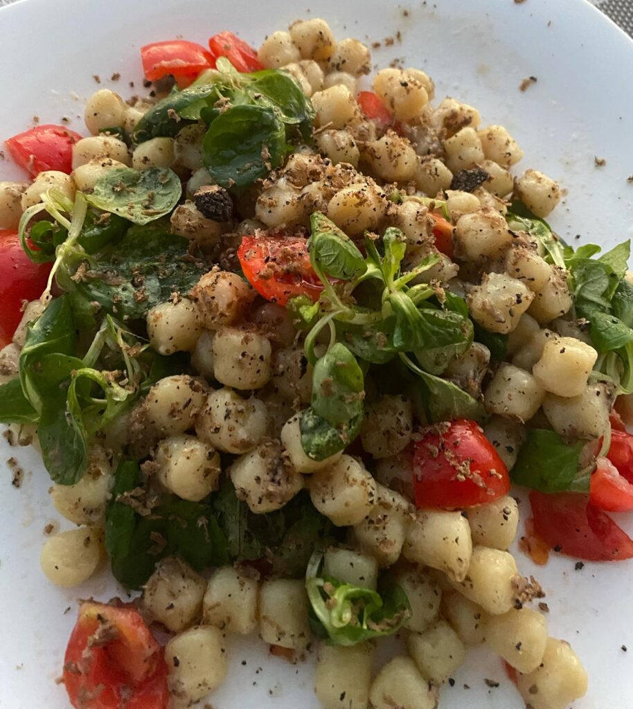 Piatto di gnocchi con pomodorini e valeriana